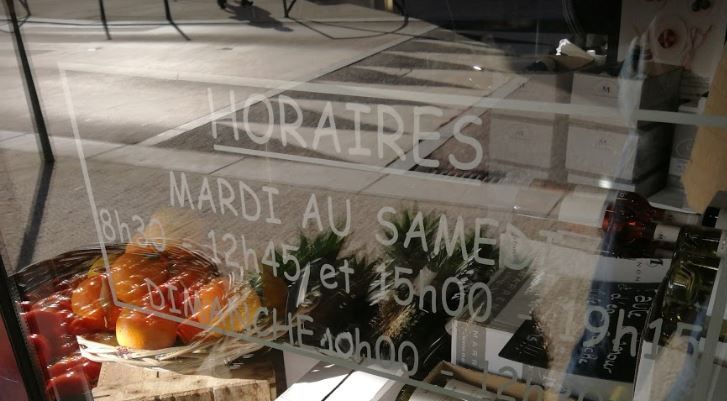 Vitrine du magasin avec fruits et horaires
